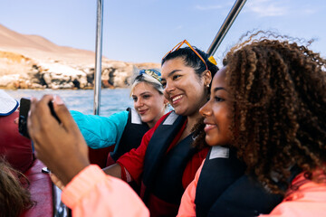 Multiethnic friends enjoying boat trip ballestas islands peru
