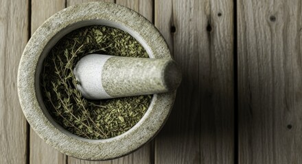 Overhead view of a rustic stone mortar and pestle filled with dried green herbs and fresh thyme sprigs on a weathered wooden surface, symbolizing natural preparation of spices and remedies.