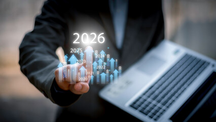Businessman drawing digital growth arrows and bar graph with 2026 target. Futuristic concept for business goals, technology strategy, data-driven planning, success and innovation.