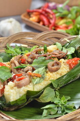 Grilled rice with stir-fried salted squid, wrapped in banana leaves, a traditional Indonesian dish.