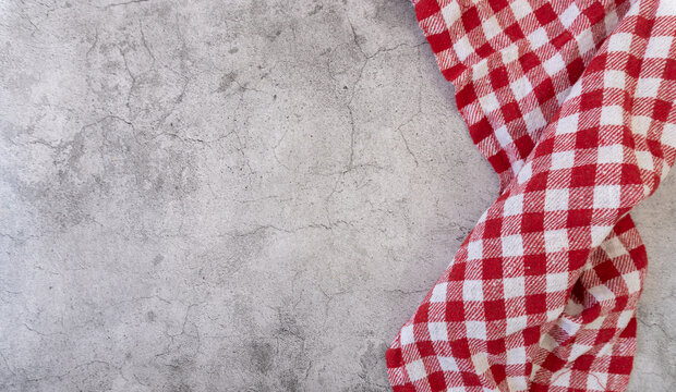 A red and white checkered cloth placed at one end of a gray concept table