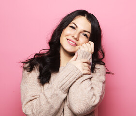 Attractive caucasian smiling brunette woman over pink background.