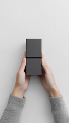 A person holding a black box in their hands