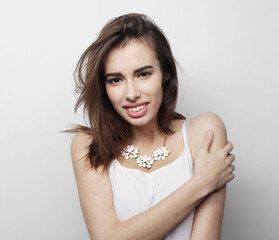 beautiful young woman wearing casual clothes, posing on light grey background.