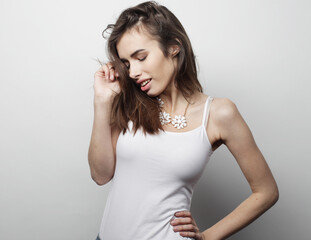 beautiful young woman wearing casual clothes, posing on light grey background.