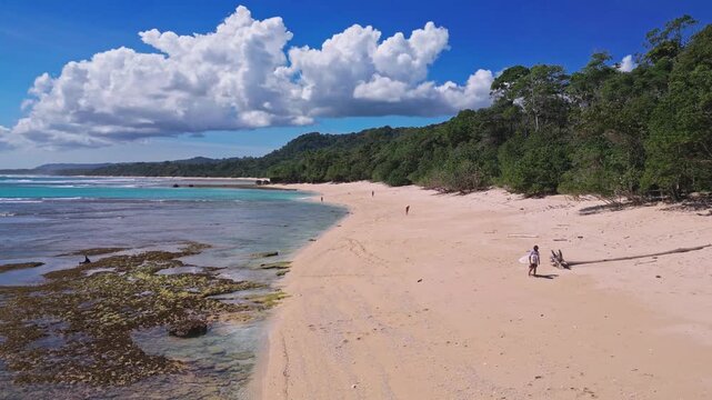 Aerial view of lonely surfer at tropical island coastline, Plengkung Beach,Alas Purwo National Park, East Java, Indonesia