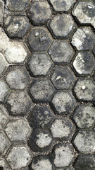 Gray Hexagonal Paving Stones on Urban Sidewalk in Weathered Condition