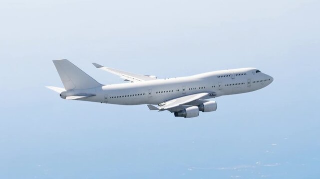 White passenger airplane Boeing 747 flying above the clouds in a blue sky background side view high angle double decker aircraft with four engine. Modern passenger jet airplane.