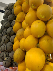 Fresh vibrant melons stacked high at the farmers market, a healthy treat perfect for summer picnics and delicious smoothies, a taste of sunshine
