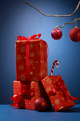 Christmas gift pile with baubles and ribbons. Vertical layout with rich red tones for festive...