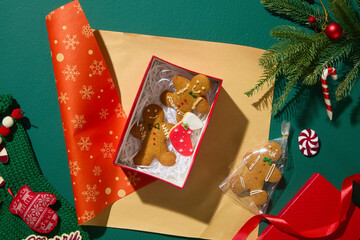 Hands packing a red Christmas cookie box with ribbon and wrapping paper. Festive creative scene for...