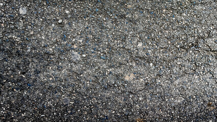 Detailed, high-resolution close-up of rough gray asphalt and bitumen road surface. Ideal full-frame texture for construction, urban backgrounds, architecture mockups, or website design.