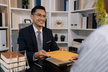 A professional lawyer discussing legal matters with a client in an office, providing legal advice...