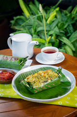 Grilled rice with shredded chicken and green chilies, wrapped in banana leaves, traditional Indonesian food