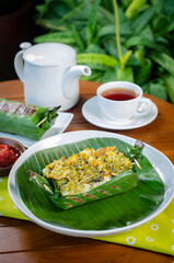 Grilled rice with shredded chicken and green chilies, wrapped in banana leaves, traditional Indonesian food