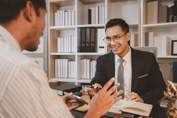 A professional lawyer discussing legal matters with a client in an office, providing legal advice...