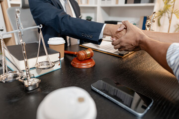 A professional lawyer in a suit shaking hands with a client in a legal office, symbolizing trust, successful agreement, and justice in legal consultation and professional law service.