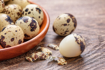 Obraz premium Closeup view of quail eggs in wooden plate on table