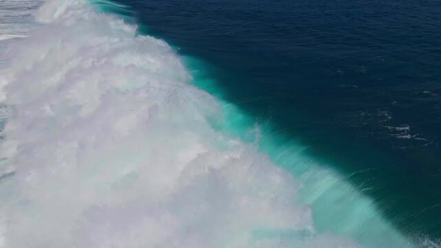 Cinematic aerial top-down of a breaking wave in reverse &ndash; Creative ocean backwash and turquoise water textures in Bali, Indonesia