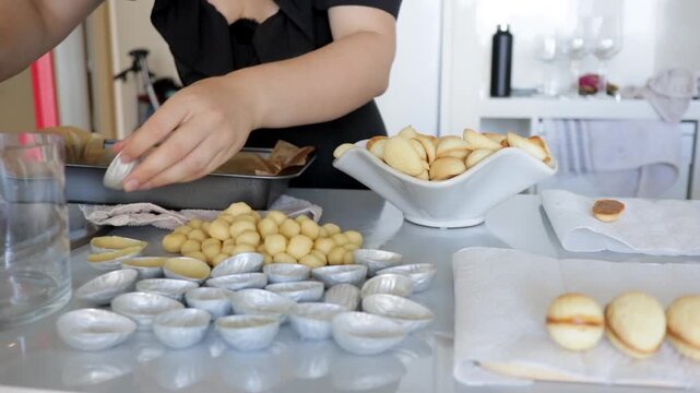 Kitchenside scene with cookie stacking and baking tools, Intimate domestic environment featuring baker organizing cookies with various baking implements and equipment