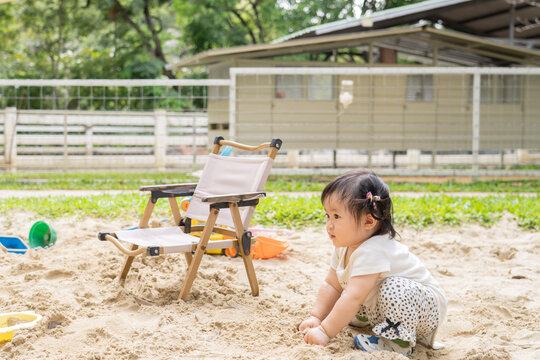 little girl playing on the sand box