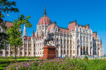 Hungarian Parliament in Budapest with Ferenc Rakoczi II statue on a sunny day.