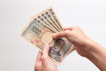 手に持って広げた千円札5枚の写真 (女性　北里柴三郎　新紙幣　現金　白背景)