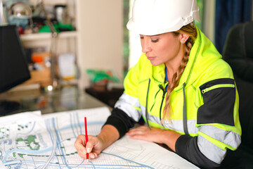 Woman builder professional architect  working on architectural plans blueprints in office