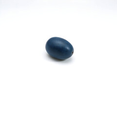A single, plump, blue grape with a slight sheen to its skin, resting on a clean and pristine white background