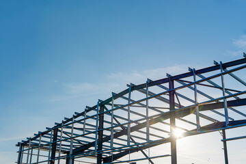 Steel frame structure under construction against blue sky