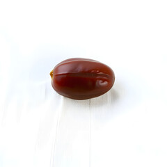 A solitary, plump, and vibrant Date fruit with a smooth brown skin and a subtle sheen, placed gently on a crisp, linen white background