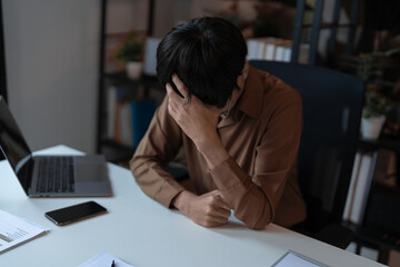 Stressed Tired Male Employee Sitting at Desk in Company Office