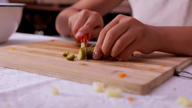 Preparing sliced gherkins for dishes, Skillfully cutting brined cucumbers for culinary use, Home cook slices tiny pickles on chopping board for garnishing and flavoring