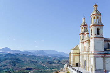 Olvera town church towering above fertile olive groves and rolling mountains in olvera,cadiz,spain