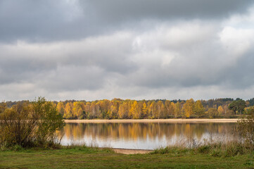 Quit river on background of forest in autumn leaf colours.