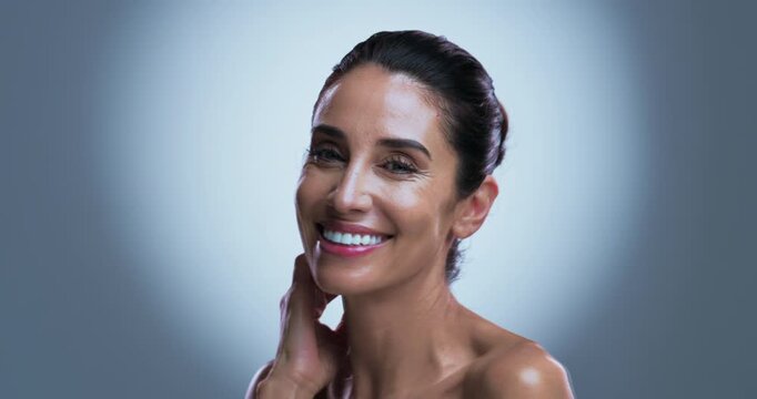 Face, mature and happy woman in studio with skincare for collagen, retinol and anti aging benefits. Confident, smile and female person with beauty, dermatology and smooth skin on grey background.