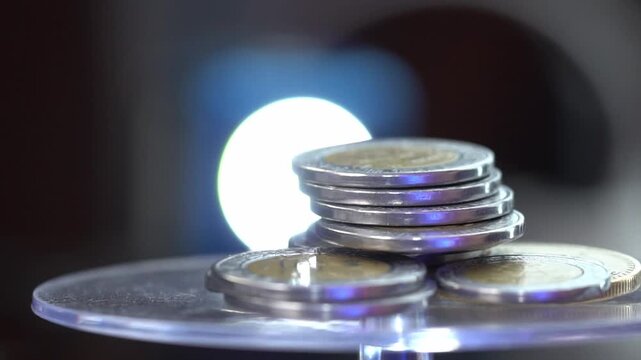 Stack of bimetallic coins with a glowing backlight for a financial concept