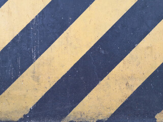Textured Concrete Surface with Diagonal Yellow and Dark Gray Stripes