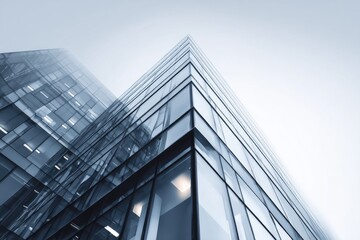 Obraz premium High-angle shot showcases a modern glass skyscraper in an overcast sky. Architectural detail