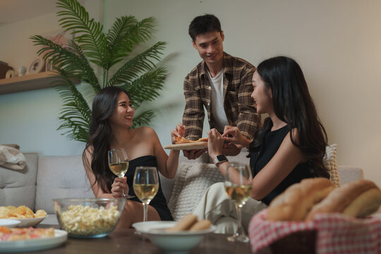 Young friends sharing pizza and drinks at home party