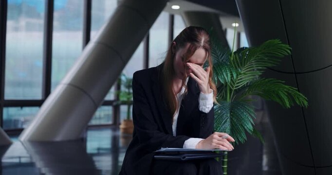 Thoughtful and stressed businesswoman in slow motion, deeply contemplating a business problem or failure, showing the pressure of corporate leadership and decision-making