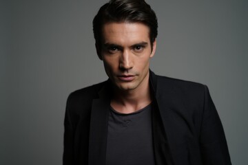 Fototapeta premium Contemporary Portrait of a Serious Young Man with Sharp Features and a Confident Gaze Against a Subtle Background