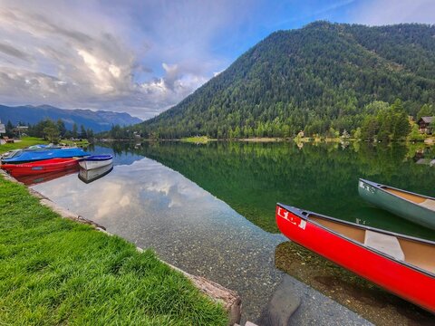 High resolution color image of the beautiful and peaceful lake of Champex Lac- Switzerland with the alp mountains in the background and red paddle-boats in the foreground