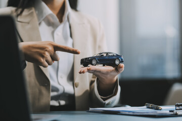 Business car rental company service, Close up hand of agent dealer giving, holding car key to customer renter, new owner after signed rental, purchase contract in document, vehicle sales agreement.