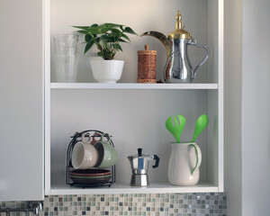 White wooden shelves and objects in home kitchen. Traditional space planning and interior design in Europe.