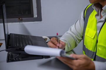 A skilled engineer is seriously planning a warehouse expansion for a large manufacturing plant. © akarapon