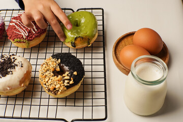 A child’s hand reaching for colorful donuts that are not allowed to eat, symbolizing temptation...