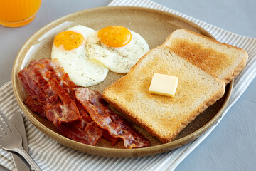 Homemade American Bacon Egg and Toast Breakfast on a Plate, side view. Close-up.