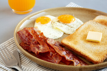 Homemade American Bacon Egg and Toast Breakfast on a Plate, side view. Close-up.