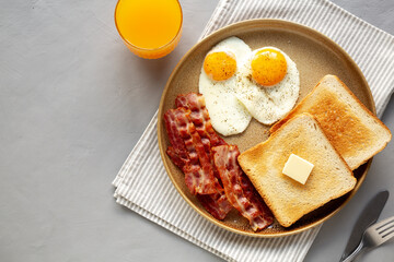 Homemade American Bacon Egg and Toast Breakfast on a Plate, top view. Copy space.